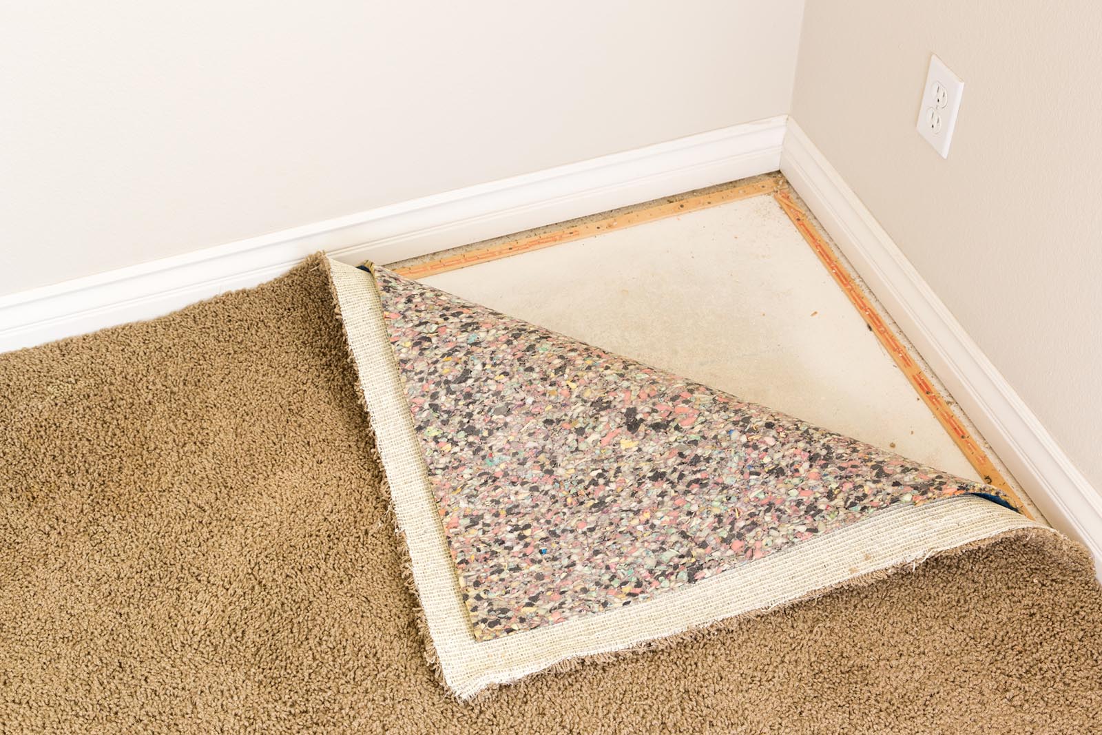 Pulled Back Carpet Flooring and Padding In Room